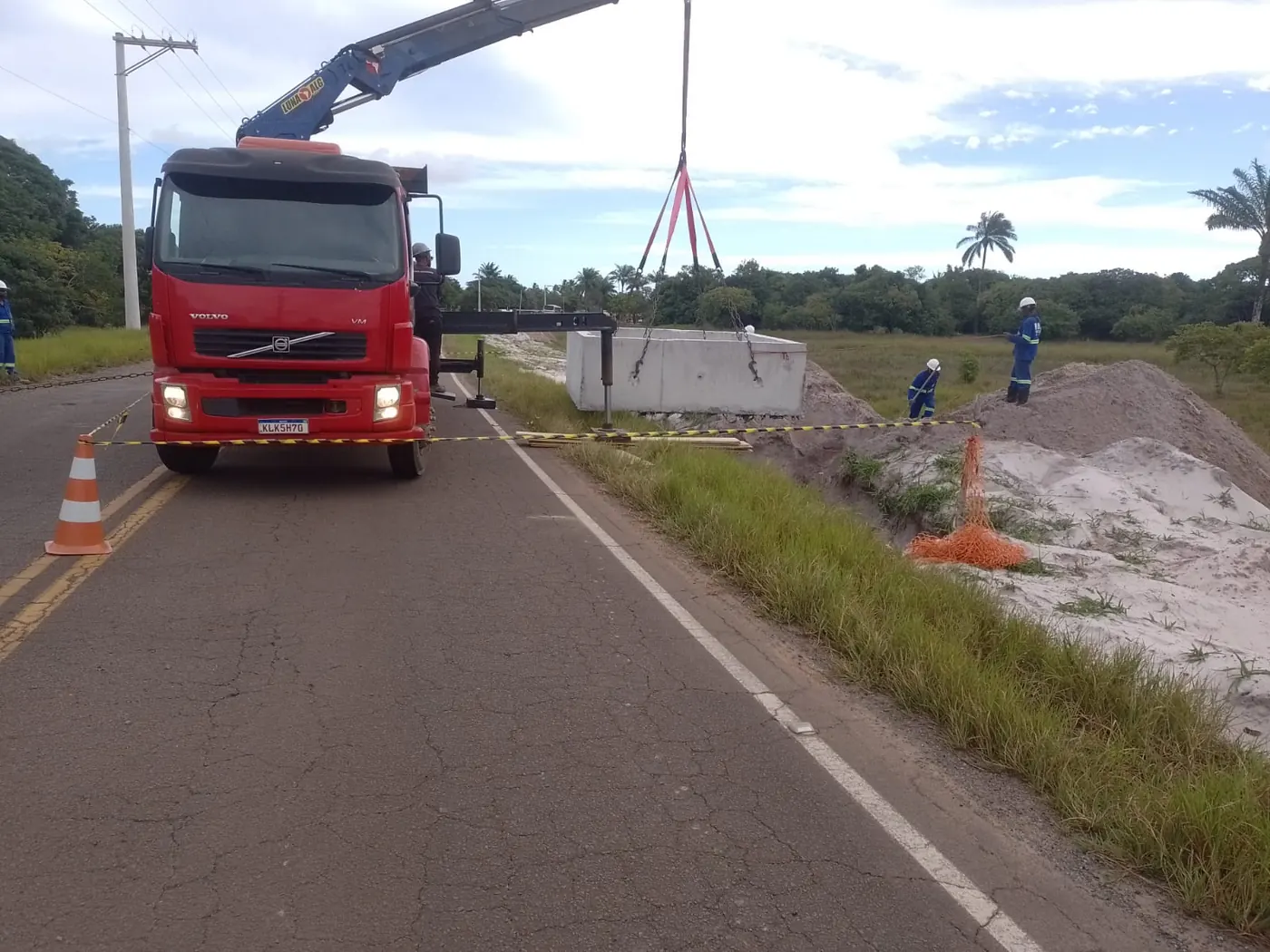Caminhão munck posicionado na rodovia durante a obra dos alimentadores do Atracadouro